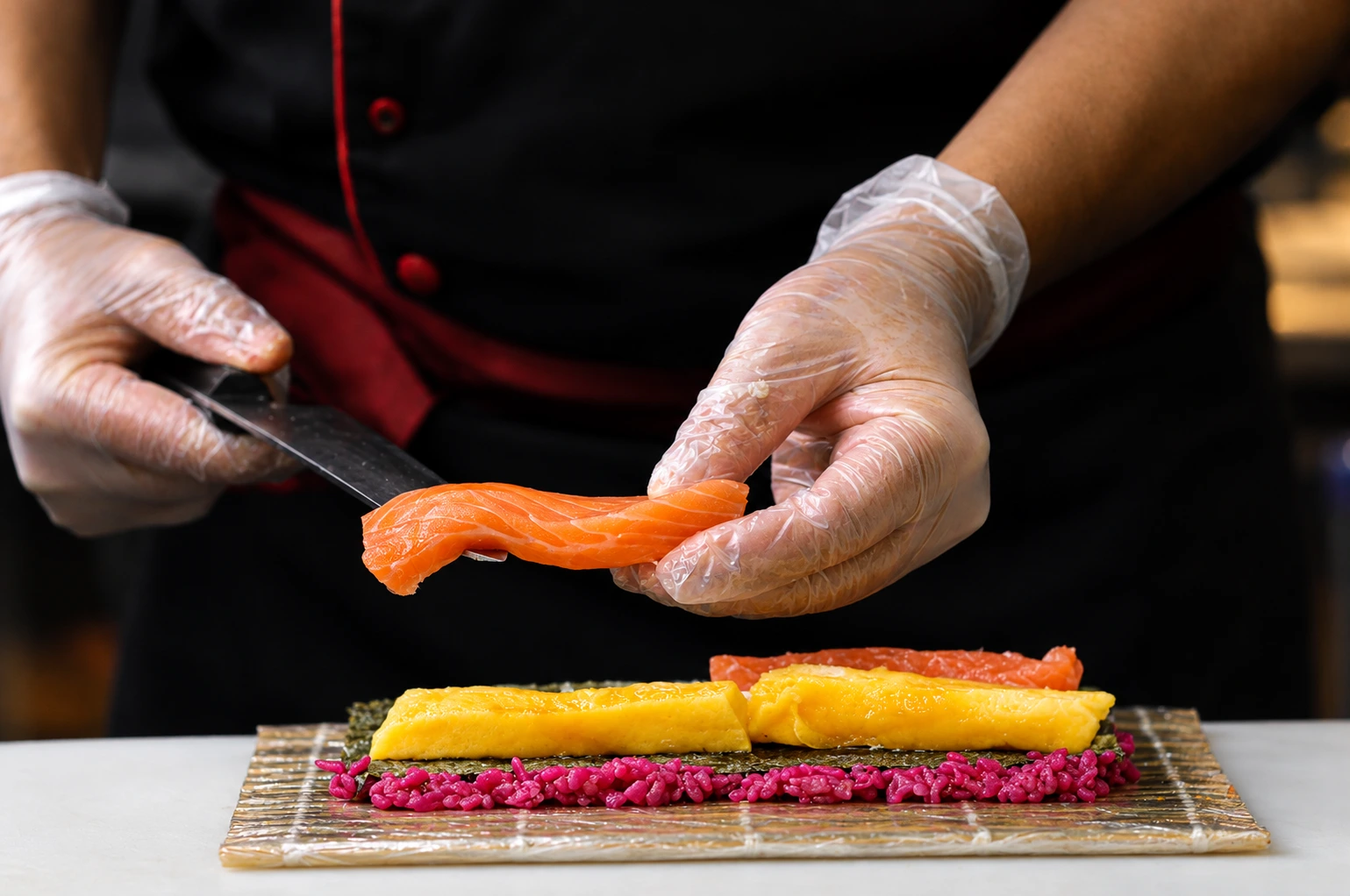 Chef crafting salmon sushi rolls